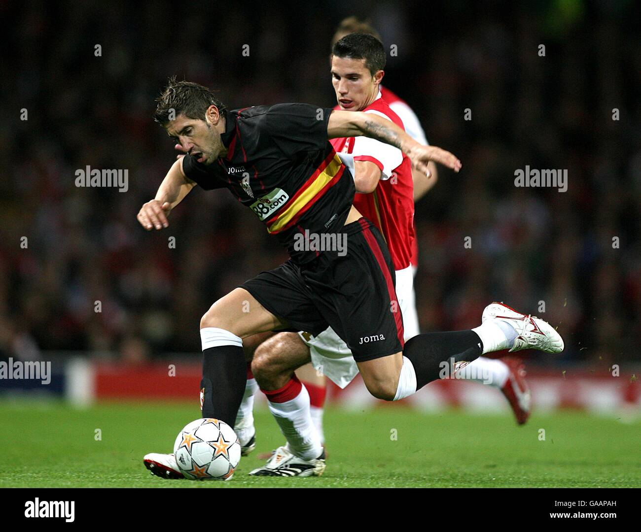 Robin Van Persie del Arsenal (r) e Ivica Dragutinovic de Sevilla (l) lucha  por el balón Fotografía de stock - Alamy