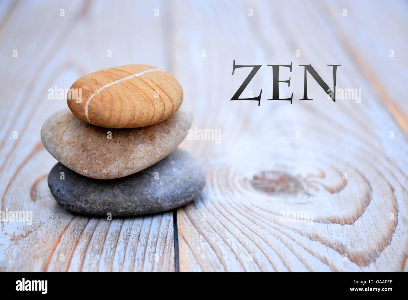 Tres cairn Zen natural piedras amontonadas sobre un fondo de madera gris antiguas con copia espacio vacío Foto de stock