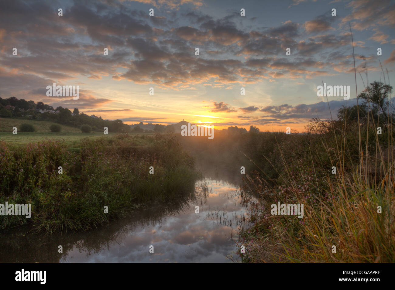 Río Brue, al amanecer con Glastonbury Tor en antecedentes, Somerset, Reino Unido, Agosto. Foto de stock