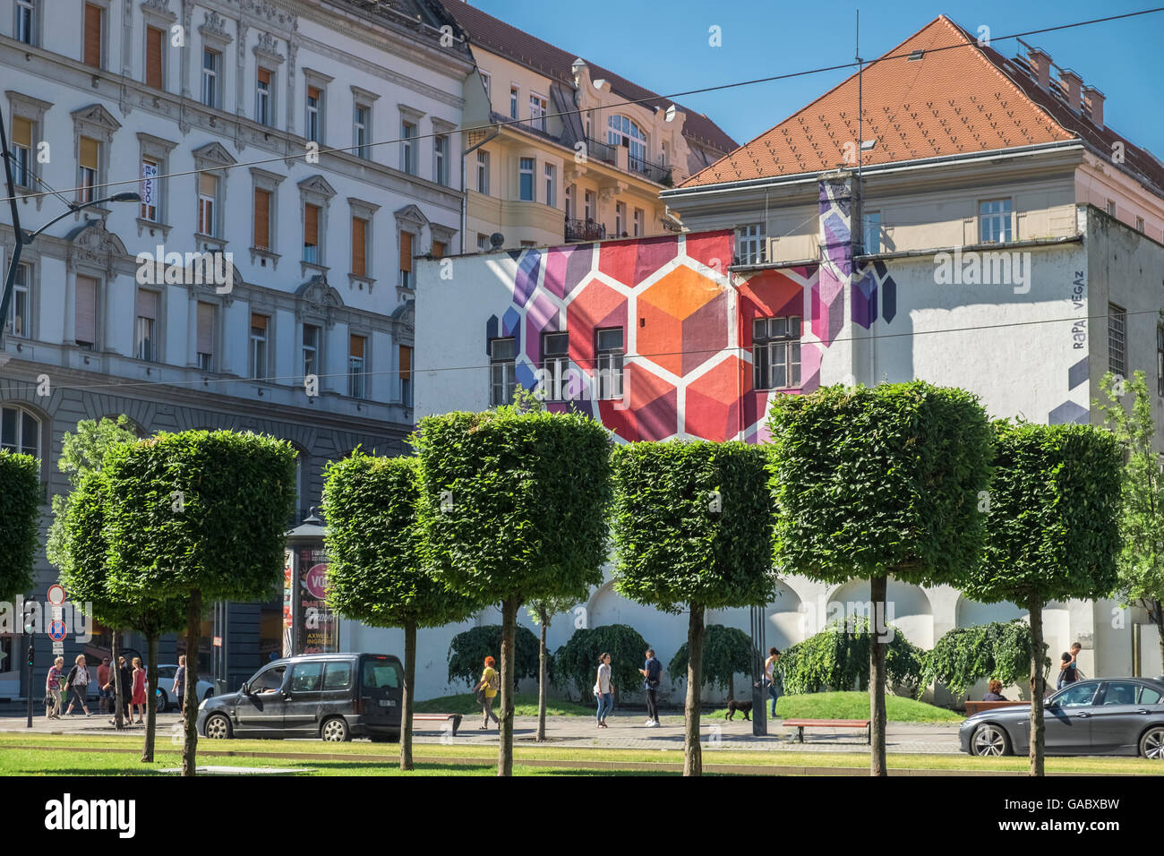 Arte en la calle, que comprende la construcción mural y recorta los árboles, en Karoly Krt, Budapest, Hungría Foto de stock