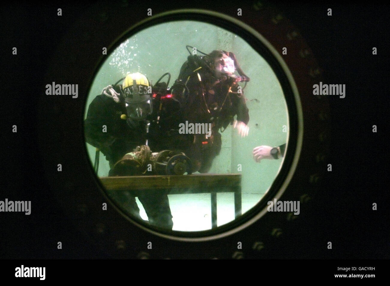 El Príncipe Harry (centro) durante su visita al escuadrón de buceo de la flota de la Royal Navy en la Isla Horsea en Portsmouth, donde realizó algunas tareas de ingeniería subacuática. Foto de stock