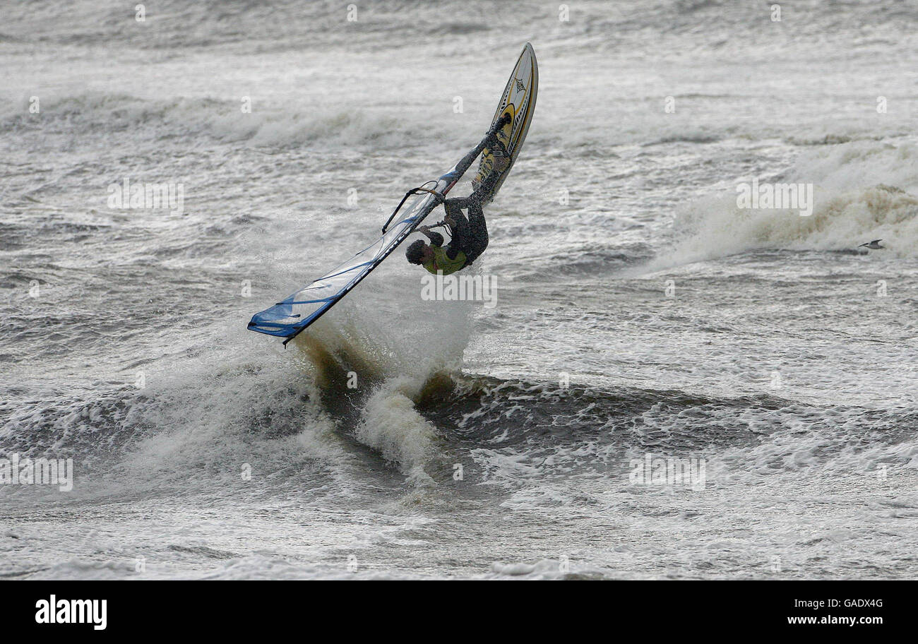 El surfista de viento Mark Killeen de Co Clare braves los vientos fuertes cerca de Lahinch en la costa oeste de Irlanda. Foto de stock