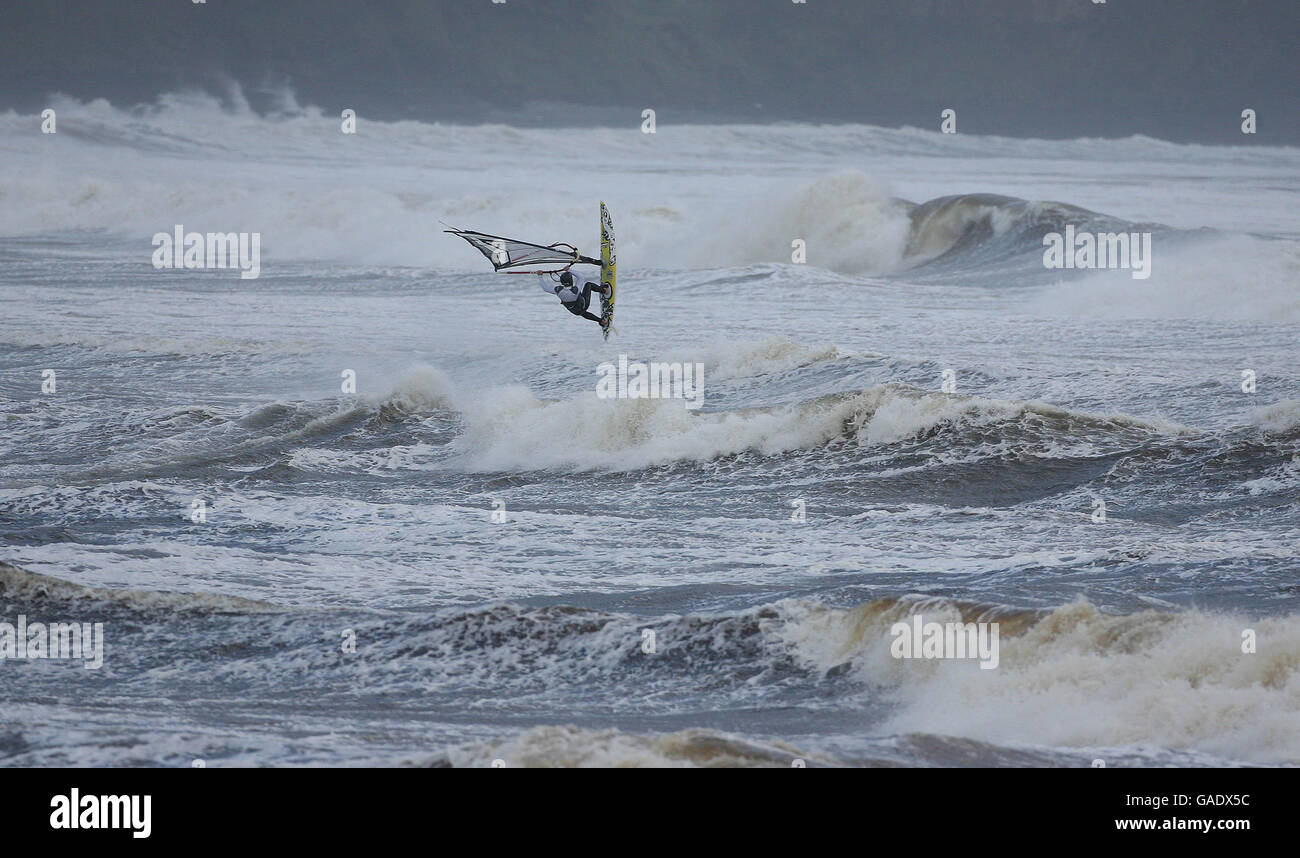 El surfista de viento Alan Kavanagh de Co Clare braves los vientos fuertes cerca de Lahinch en la costa oeste de Irlanda. Foto de stock