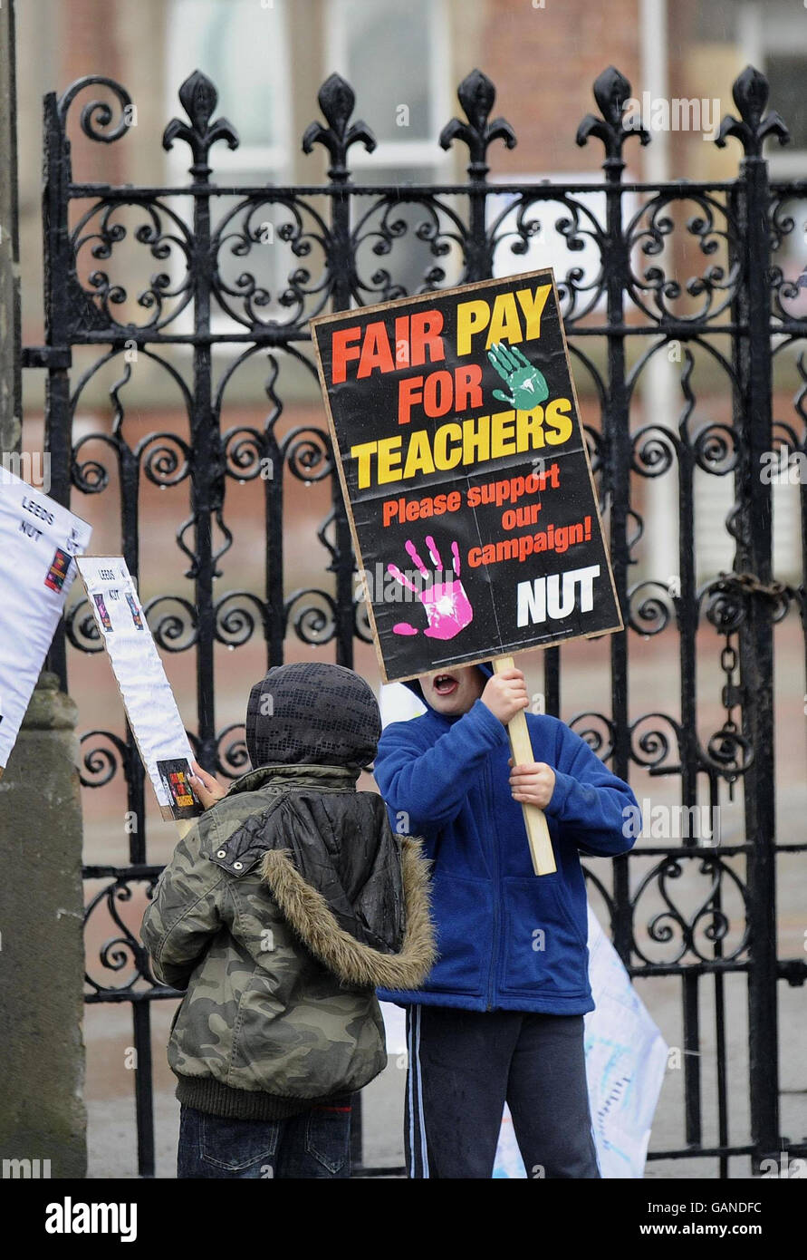 Huelga de profesores. Jóvenes partidarios que sostienen pancartas apoyan la huelga de la Unión Nacional de Maestros, fuera de una escuela en Leeds. Foto de stock