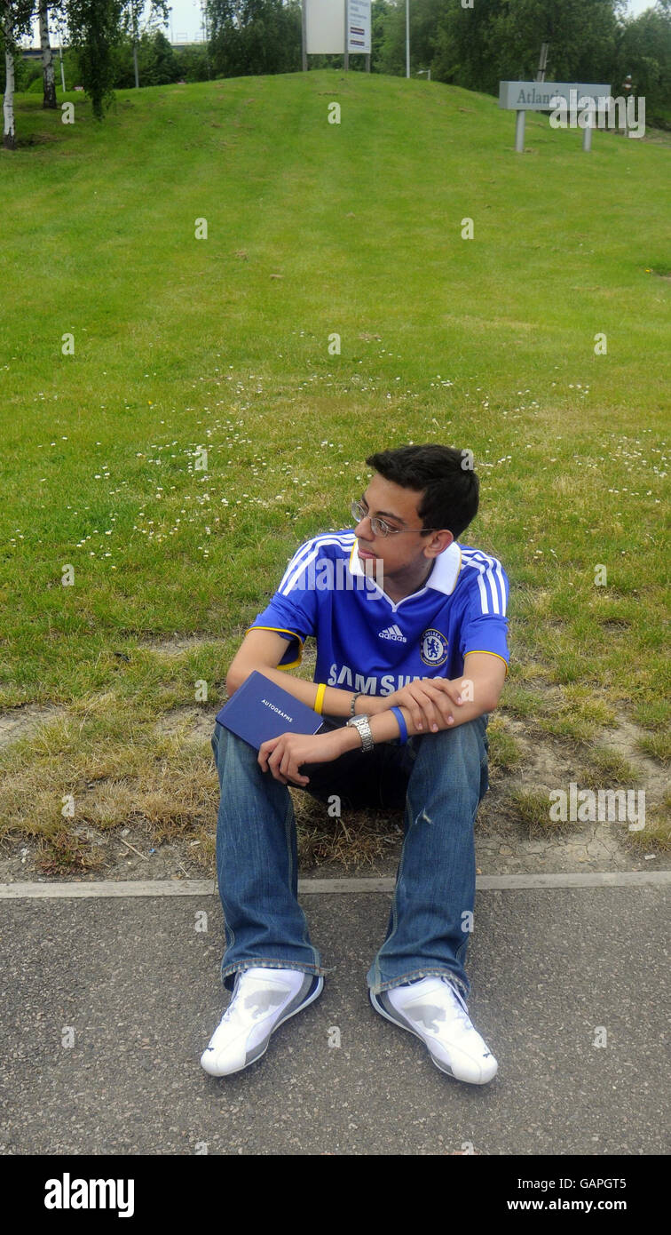 Danny Choueiri, fan de Lone Chelsea, se sienta con su libro de autógrafos mientras espera a que su equipo regrese al aeropuerto de Gatwick, Londres. Foto de stock