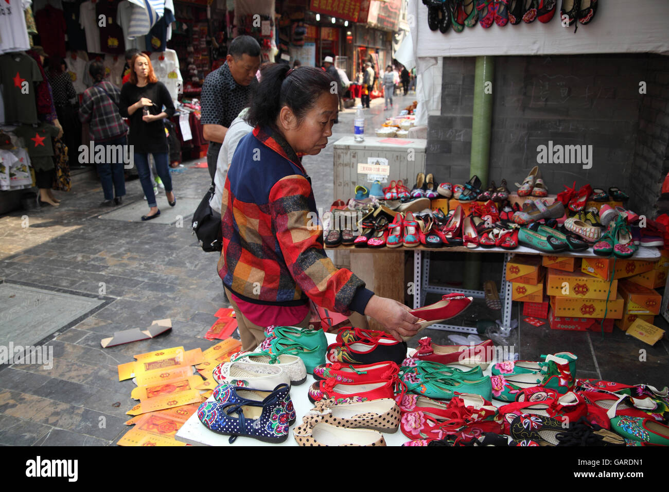 Inspiración Diálogo Amplificar Una mujer china se encuentra en un mercado abierto mirando zapatos baratos  se pueden comprar. Qibao Old Street. Beijing, China. 26.04.2016 Fotografía  de stock - Alamy