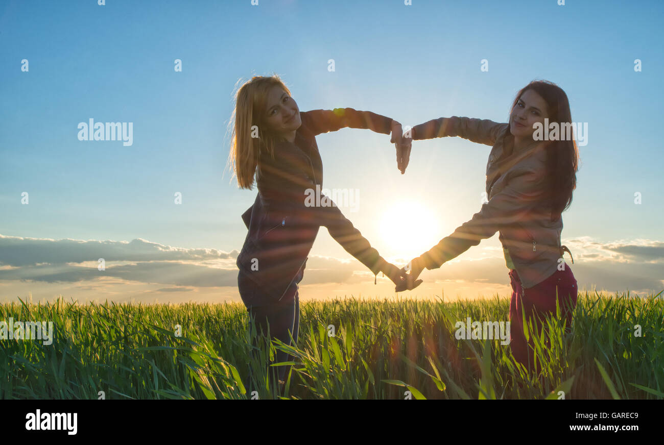 Sunset corazón hecha por dos niñas Foto de stock