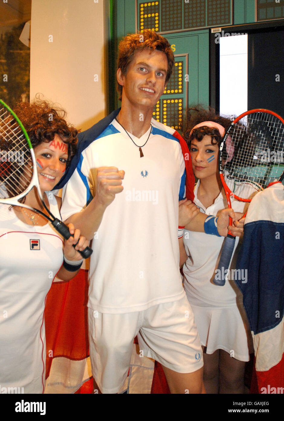 Los aficionados al tenis de Wimbledon posan para hacer fotos con una cera  del jugador británico de tenis Andy Murray en Madame Tussauds en el centro  de Londres Fotografía de stock -