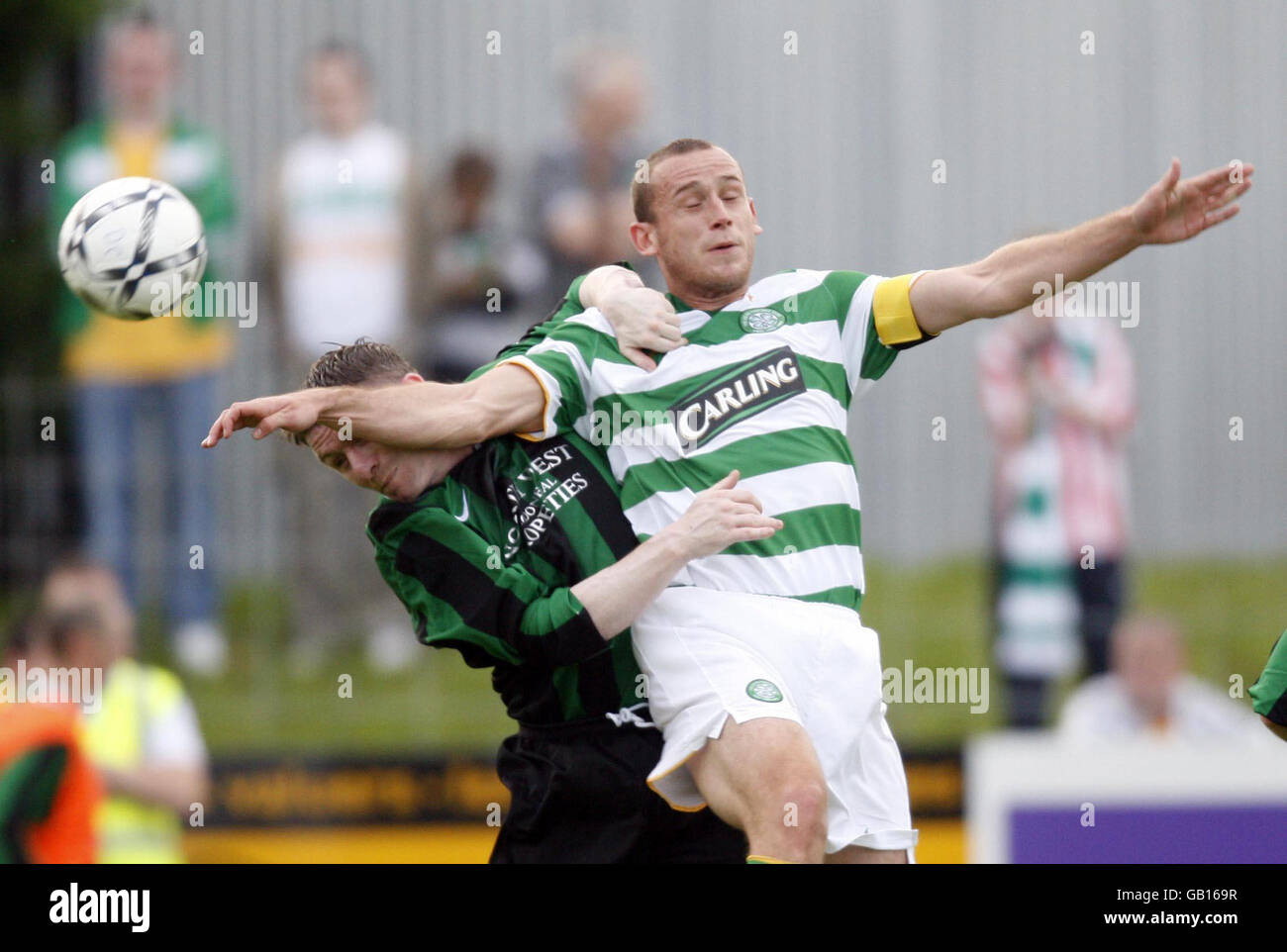 Scott Cuthbert de Glasgow Celtic, derecha, y Ciaran Gargan de Donegal Celtic lo baten por el balón durante un partido amistoso en el suelo de Donegal Celtic en Belfast Occidental, Irlanda del Norte, el miércoles Foto de stock