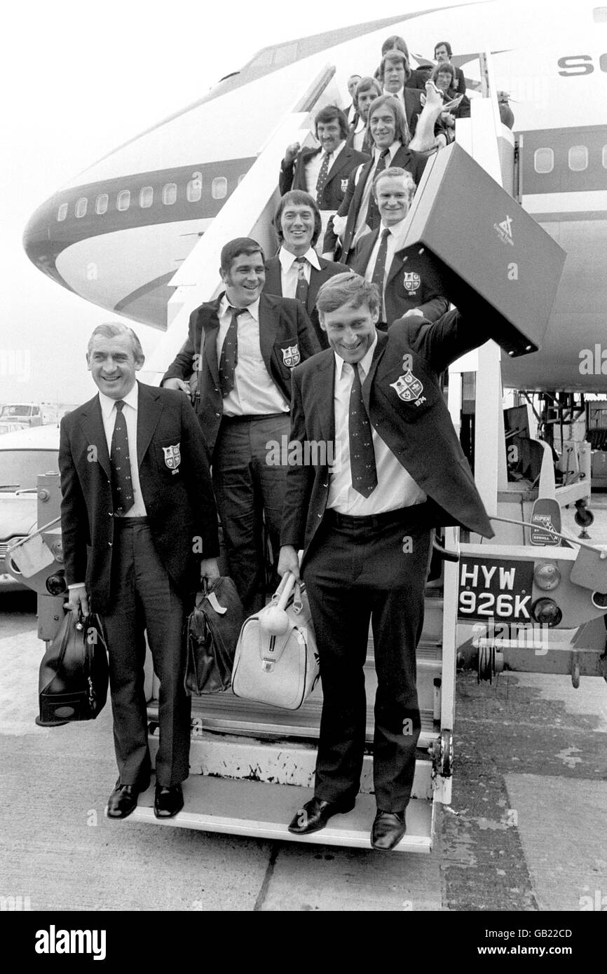 El capitán de los Leones británicos Willie John McBride (r) reconoce a los animadores de la multitud en espera mientras dirige su equipo fuera de la South African Airways 747 en el aeropuerto de Heathrow. Los Leones fueron invicto durante la gira, ganando la serie de pruebas contra Sudáfrica con tres victorias y un empate Foto de stock