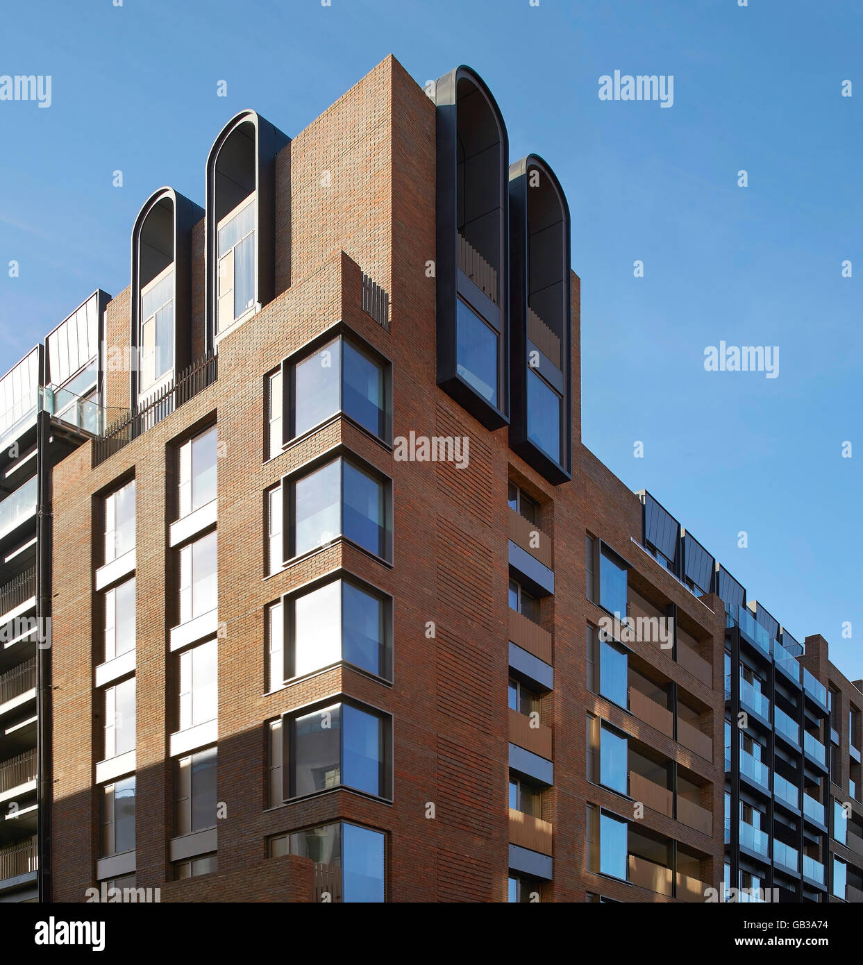 Elevación de la esquina revestidos de ladrillo rojo bloque residencial. Fitzroy Place, Londres, Reino Unido. Arquitecto: Lifschutz Davidson Sandilands, 2015. Foto de stock