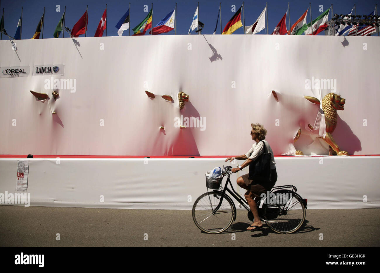 Una mujer recorre la fachada del Palazzo del Cinema en Lido de Venecia, en vísperas del Festival de Cine de Venecia de 65th, que comienza el miércoles en Venecia, Italia. Foto de stock
