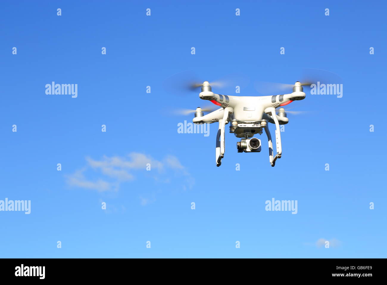 Un avión teledirigido, o UAV, o quadcopter, en vuelo bajo un intenso cielo azul. Foto de stock