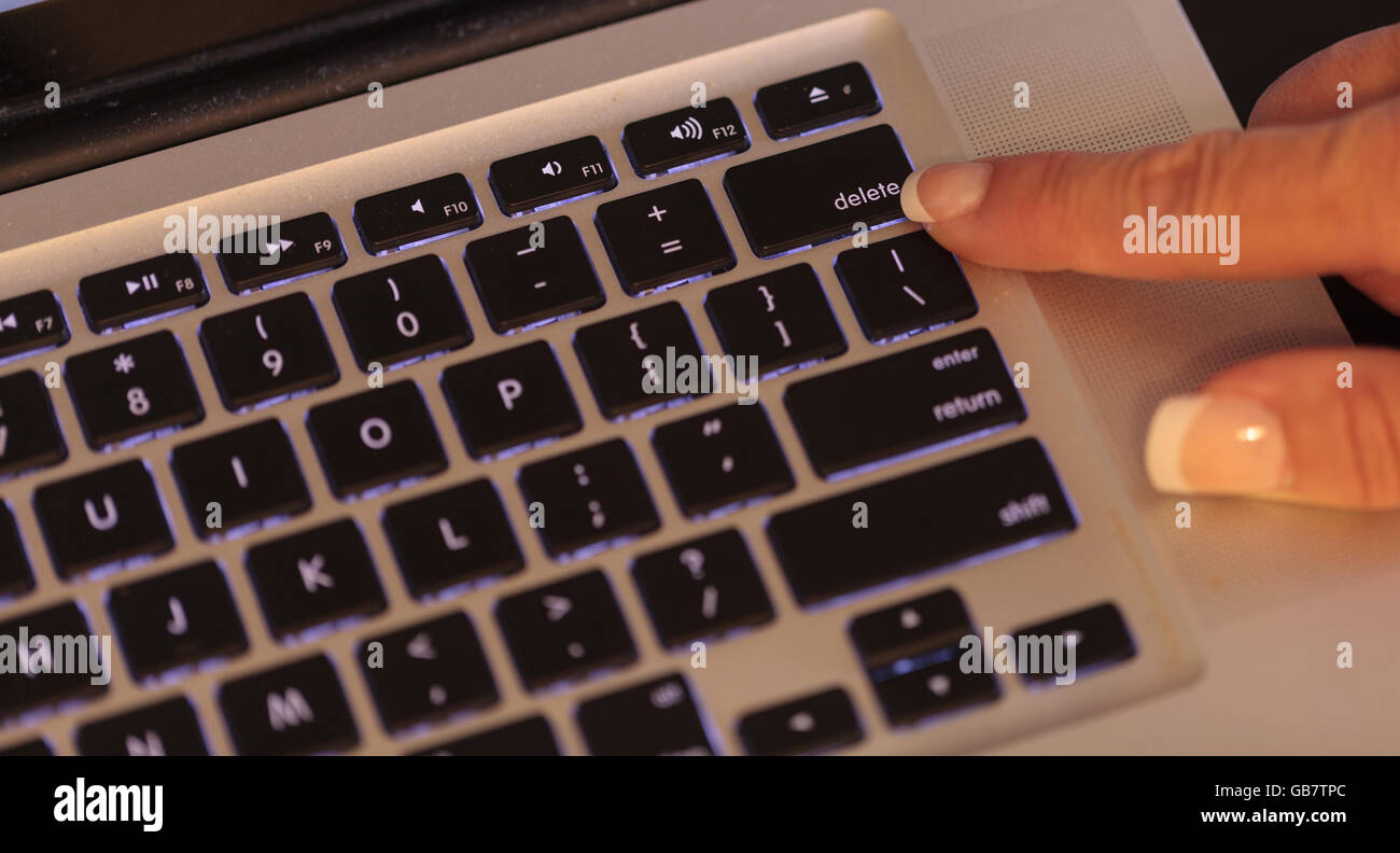 Hembra dedo sobre la tecla Supr en el teclado del ordenador en la oficina  Fotografía de stock - Alamy