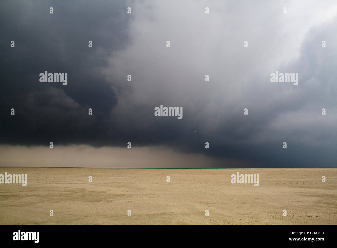 Oscuro, ominosas nubes encima de una inmensa playa Foto de stock