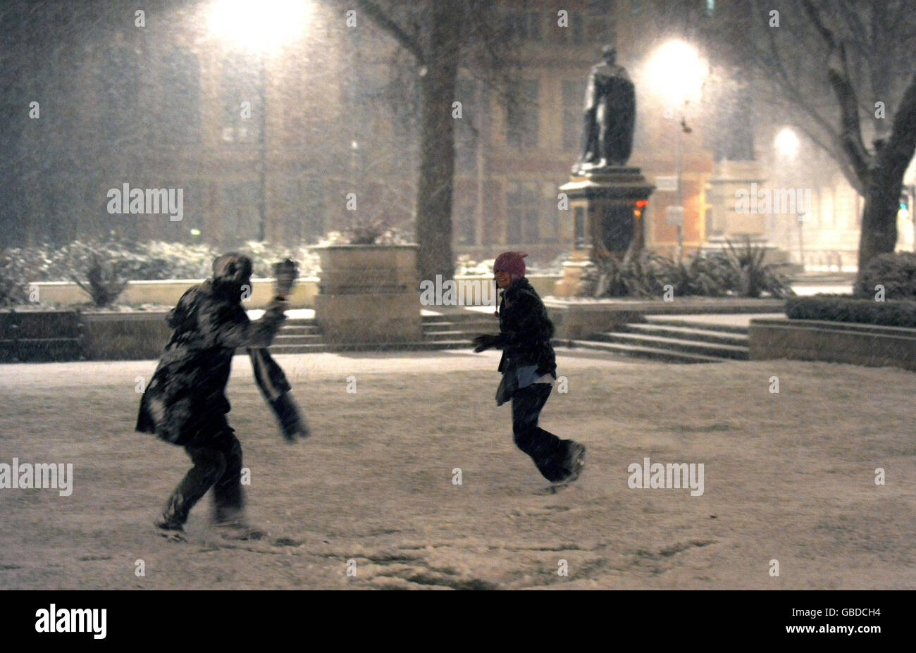 Dos miembros del público tienen una pelea de bolas de nieve en Parliament Square, Londres, cuando un momento frío golpea a Gran Bretaña. Foto de stock