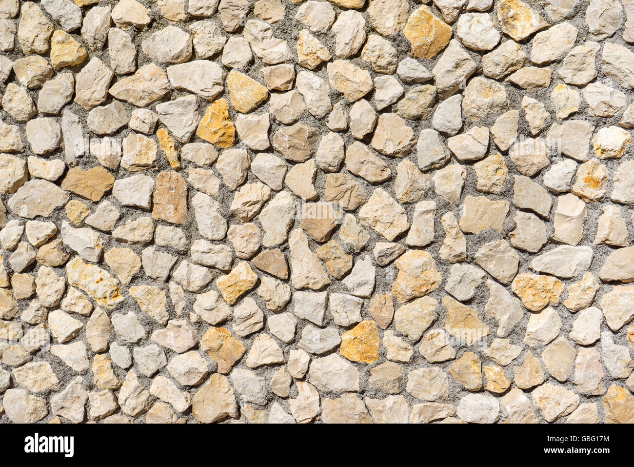 Muro de piedra natural de color beige y amarillo piedras Foto de stock