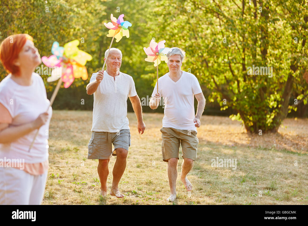 Los ancianos se divierten en el parque y la celebración de molinetes Foto de stock