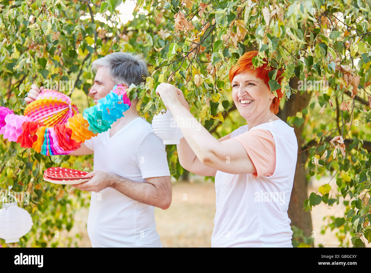 Los ancianos decorar para una fiesta de verano en el parque Foto de stock