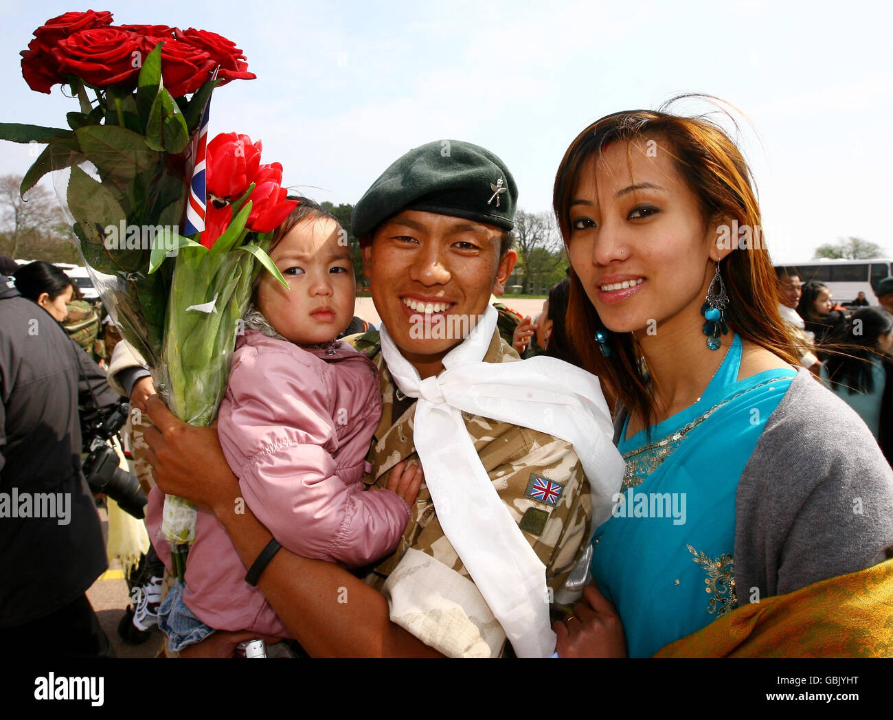 RSM Indubrkash Linbu es recibido por su esposa Sona y su hija de dos años Ingsu, ya que alrededor de 120 miembros del 2º Batallón los Rifles reales Gurkha llegan a sus cuarteles en Folkestone, Kent, después de regresar de la provincia de Helmand en Afganistán. Foto de stock