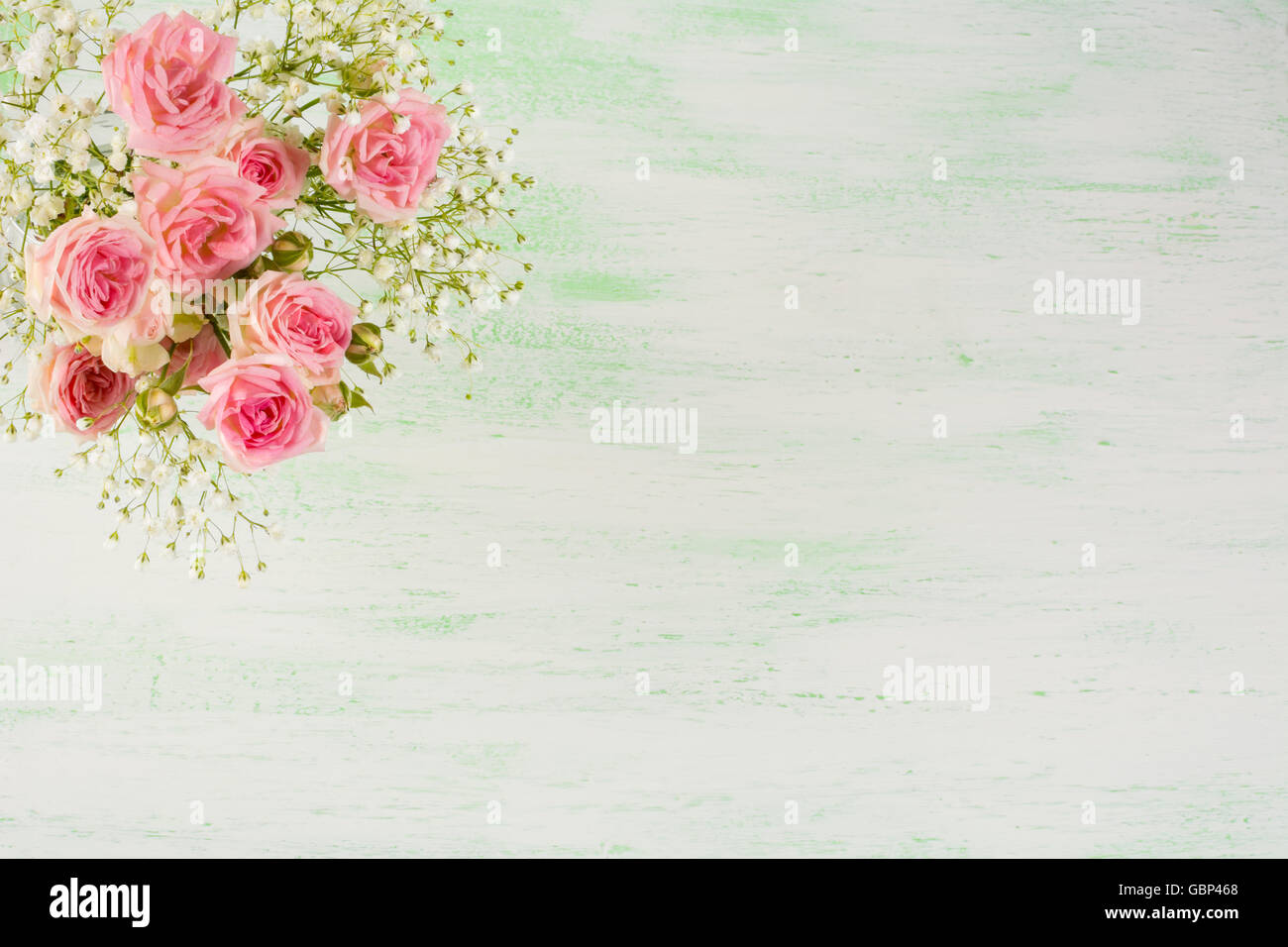 Rosa pálido rosas y flores blancas sobre fondo verde claro. Tarjeta de felicitación de flores con lugar para el texto. Foto de stock