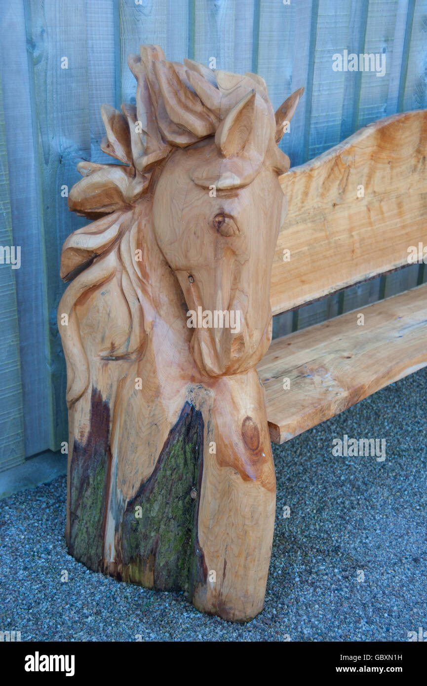 Tallado en madera de la cabeza de un caballo en un banco en RHS Rosemoor,  Devon, Inglaterra, Reino Unido Fotografía de stock - Alamy