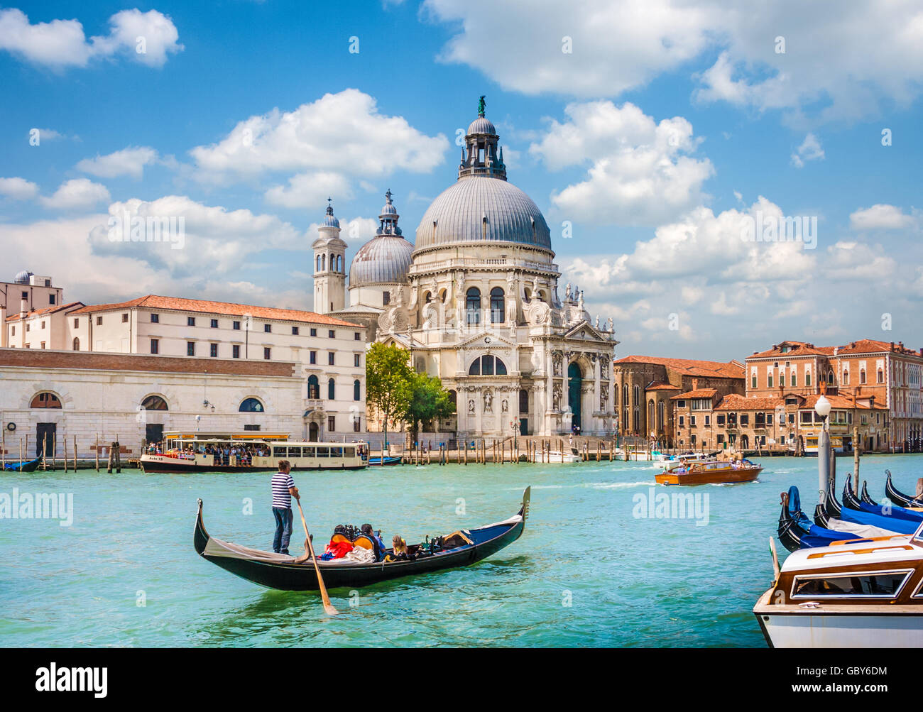 Góndola tradicional en el Canal Grande con la histórica Basílica di Santa Maria della Salute, en el fondo, Venecia, Italia Foto de stock