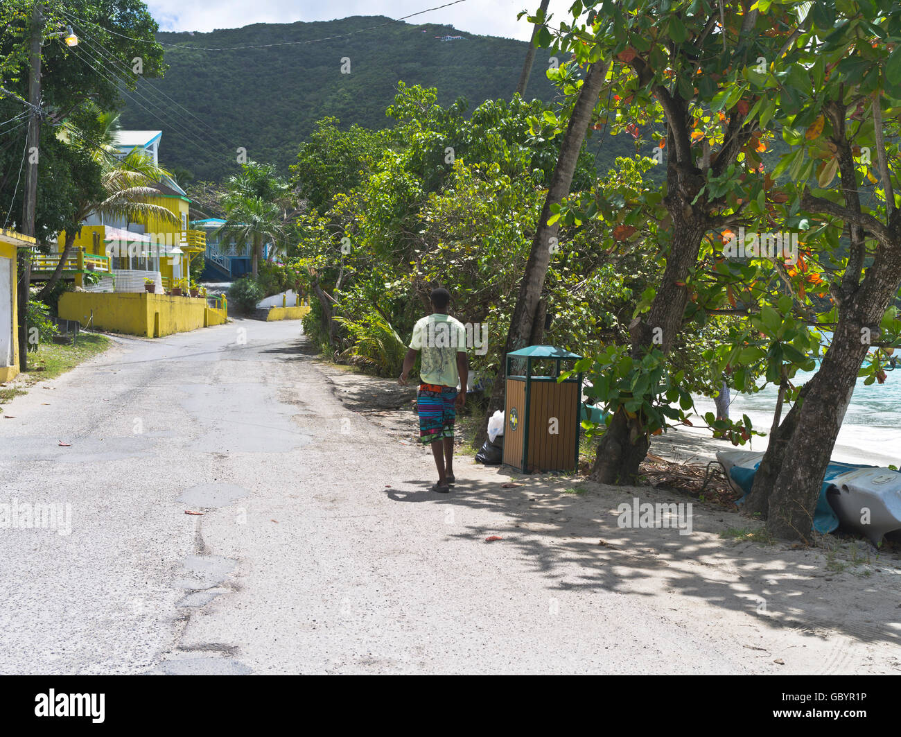 dh Cane Garden Bay TORTOLA CARIBBEAN local hombre caminando playa carretera principal Ruta 1 carreteras personas Islas de sotavento Foto de stock