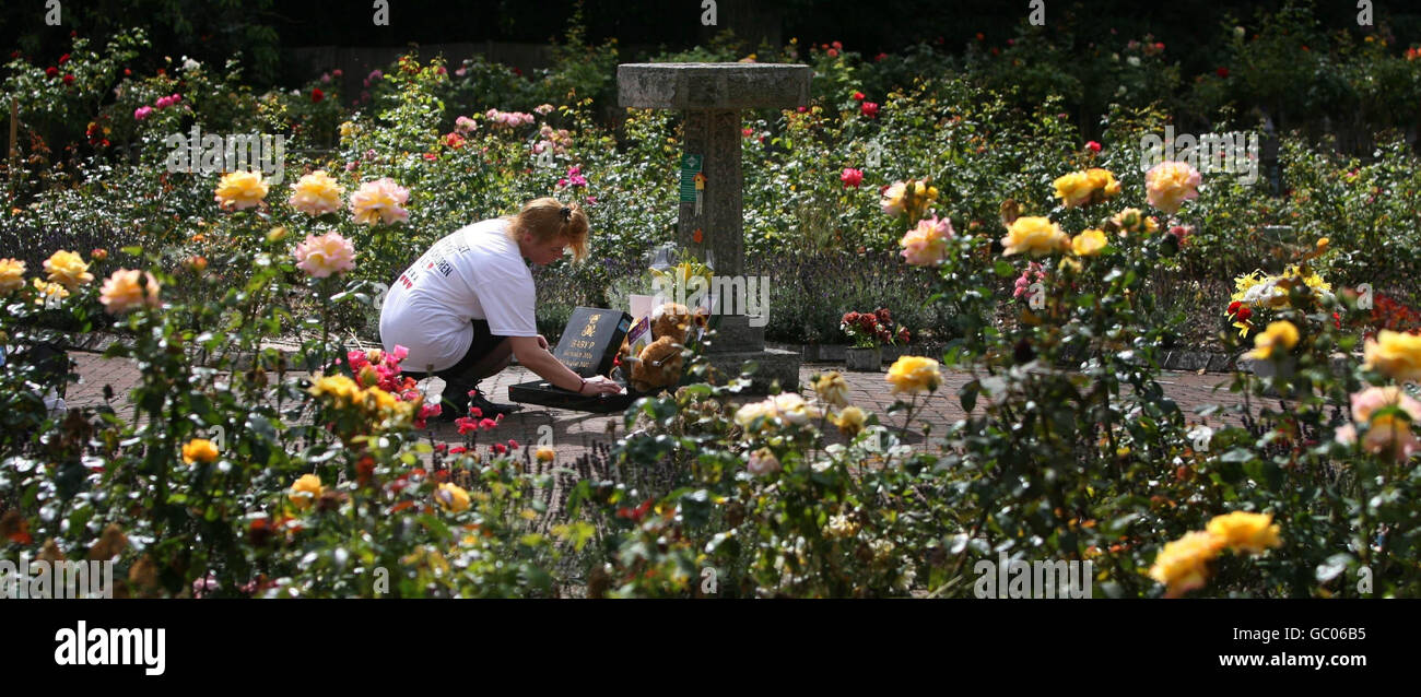 Lynda Red, de 37 años, paga sus respetos en el memorial de Baby P en el cementerio de St Pancras, East Finchley. Foto de stock