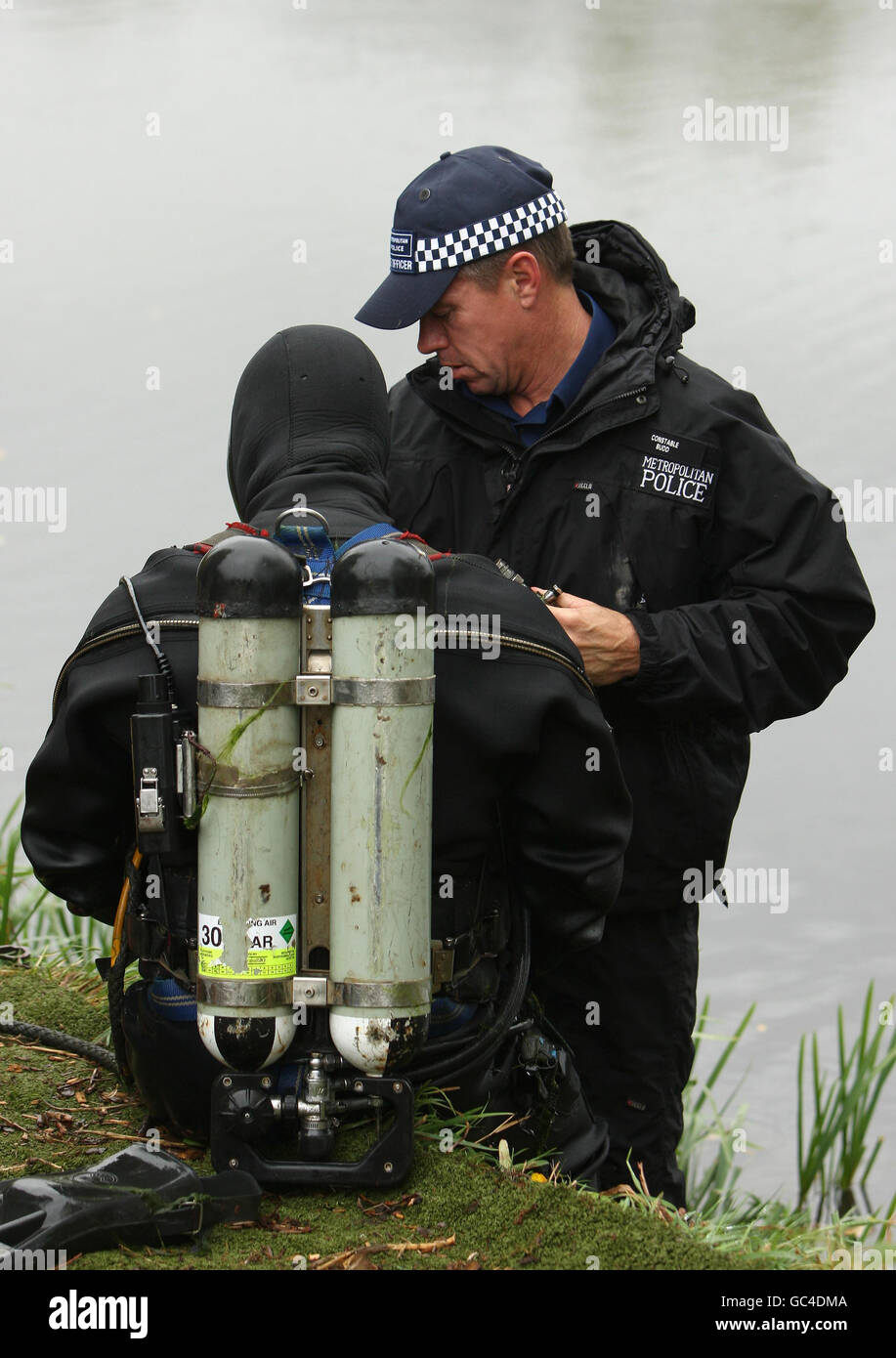 Los miembros del equipo de búsqueda subacuática de Scotland Yard investigan un lago en Bedfont Lakes Country Park, cerca de Heathrow, para los detectives de coches creer que fue utilizado para llevar el cuerpo de Milly Dowler asesinado. Foto de stock