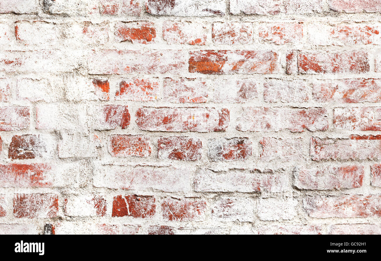 Viejo muro de ladrillo rojo con daños en la capa de pintura blanca, closeup fotografía de fondo de textura. Composición perfecta Foto de stock