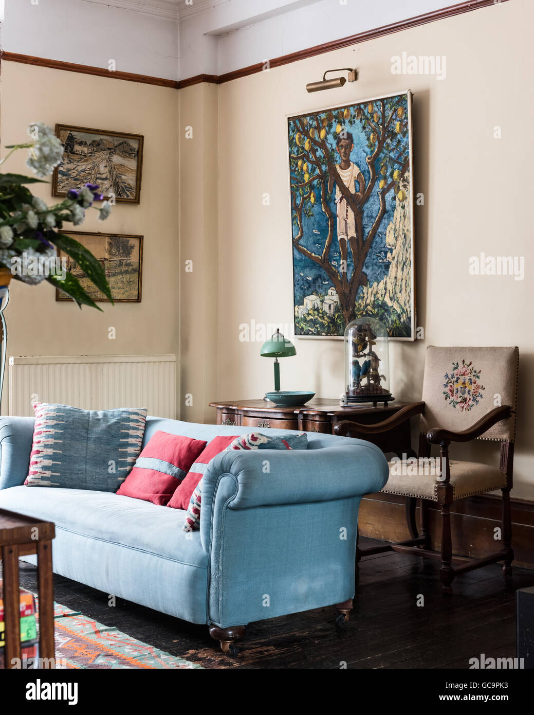Silla bordada con luz azul sofá y obras de arte en la sala de dibujo de Notting Hill, Londres, Reino Unido. Foto de stock