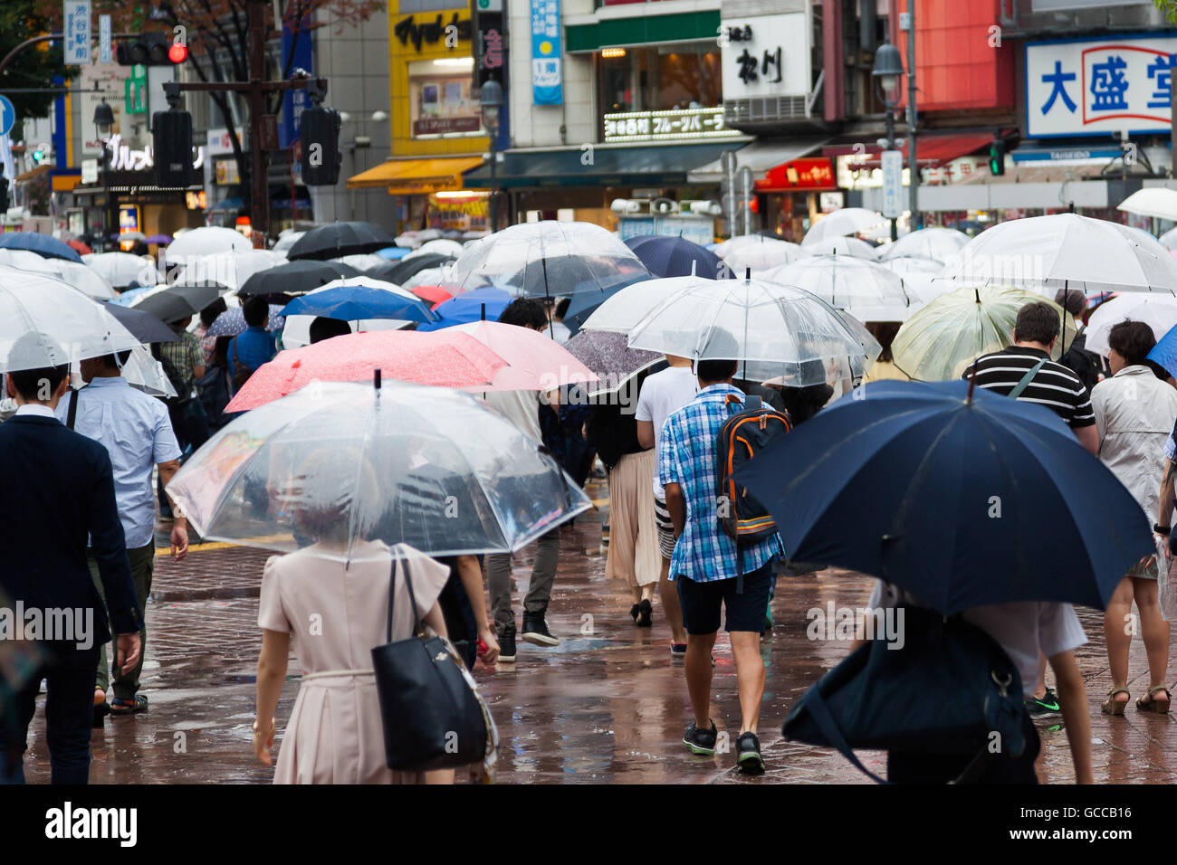 Tokio, Japón. El 9 de julio, 2016. Los peatones mantenga paraguas bajo la  lluvia en Shibuya scramble cruzando el 9 de julio de 2016, Tokio, Japón. La  temporada de lluvias anual o