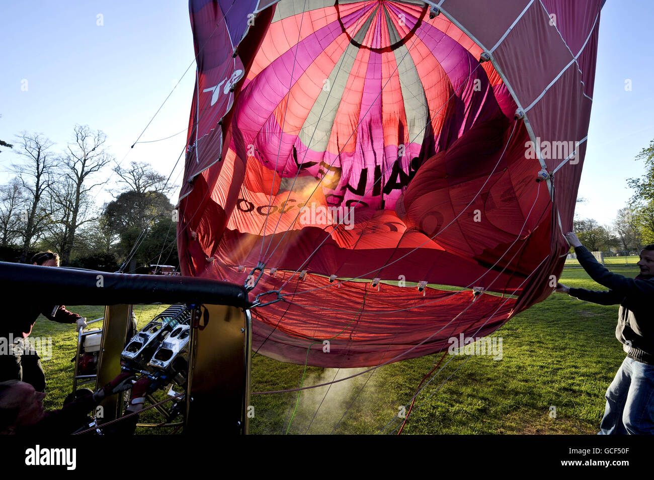 Un globo de aire caliente se llena con un quemador antes de un vuelo en una soleada mañana de primavera en Bath después de que se levante la prohibición de viajar en vuelo motorizado. Foto de stock