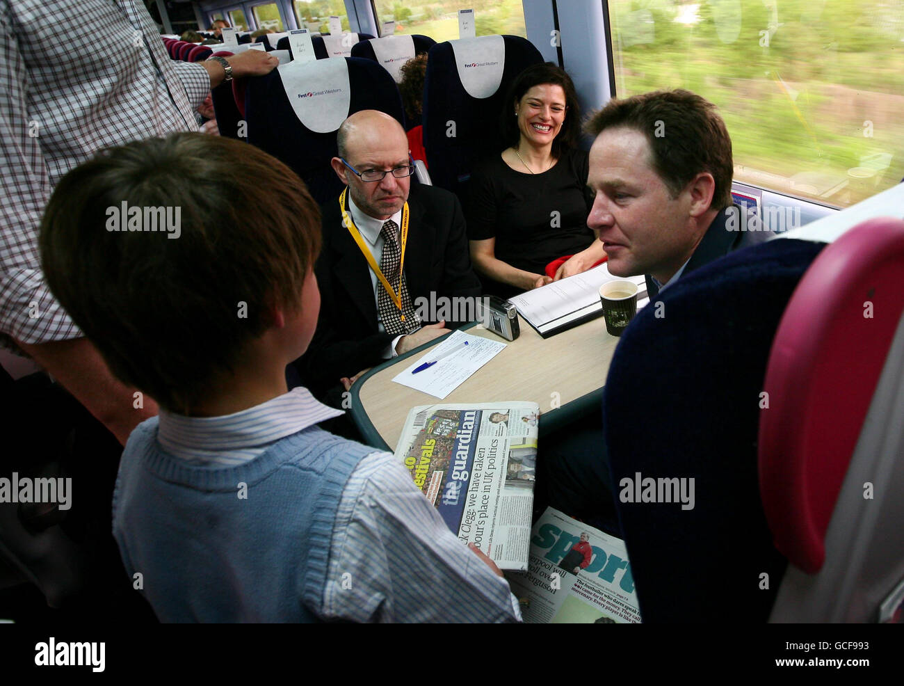 El líder demócrata liberal Nick Clegg habla con un joven partidario a bordo de un tren desde Paddington Station en Londres para una visita de campaña electoral general a Wells. Foto de stock