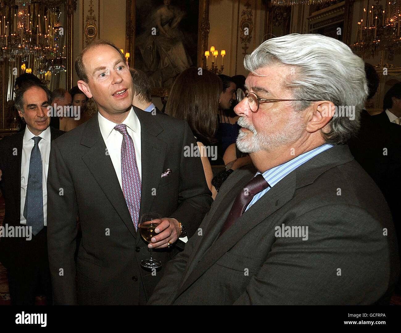El conde de Wessex se reúne con el director de Star Wars George Lucas (derecha) en una recepción de bebidas para la organización benéfica 'Cine sin Fronteras' en el Palacio de Buckingham en el centro de Londres. Foto de stock