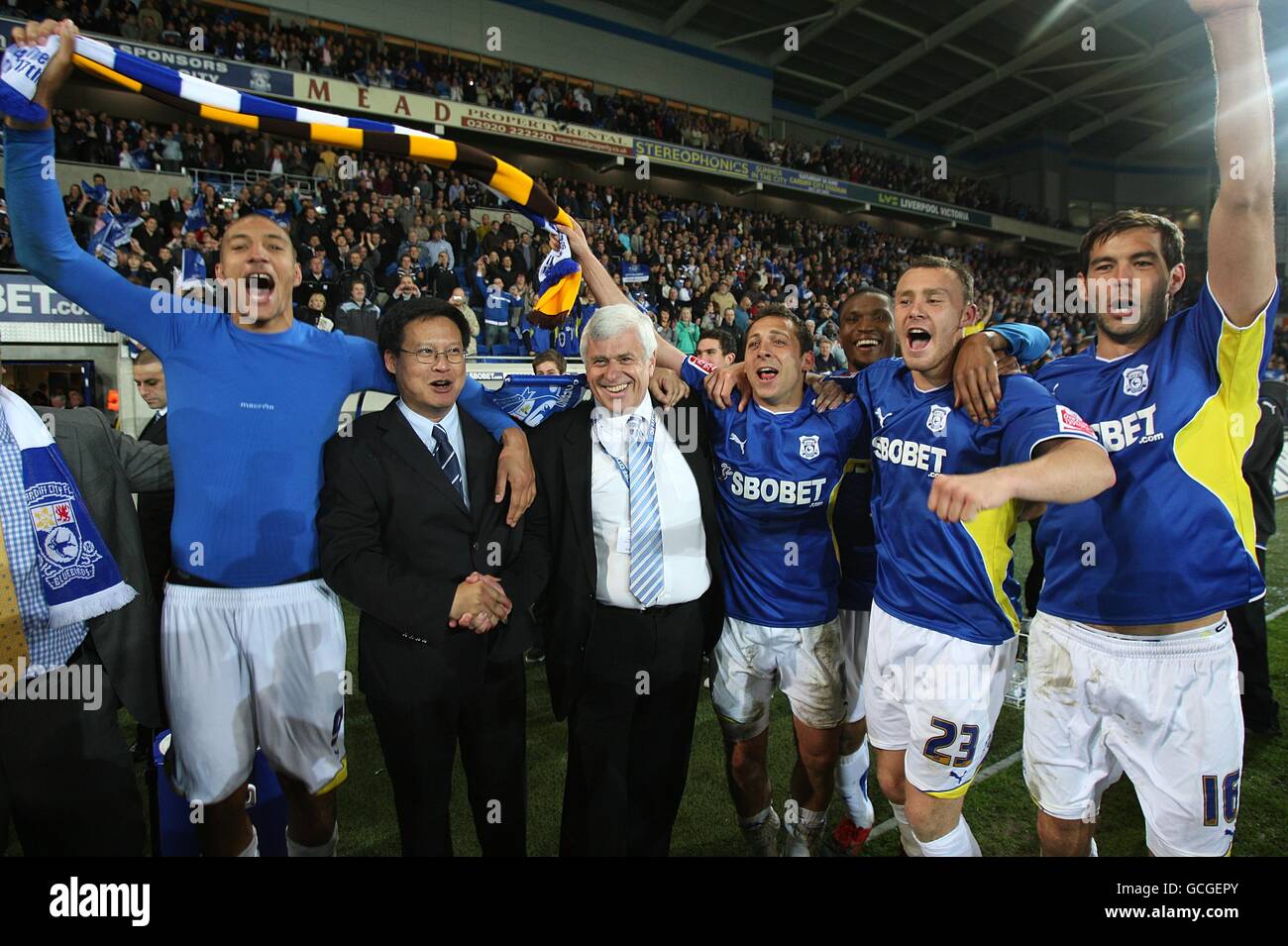 Los jugadores de Cardiff City celebran su victoria con el director malayo Dato' Chan Tien Ghee (tercera izquierda) y el presidente Peter Ridsdale (cuarta izquierda) celebran después del silbato final. Foto de stock