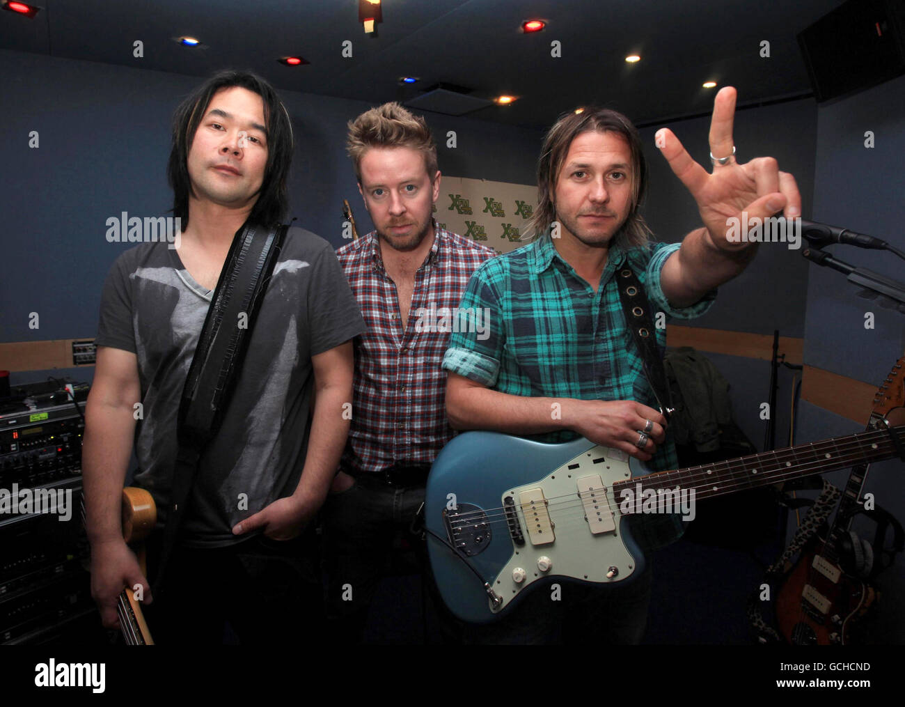 Alimentador (de izquierda a derecha) Taka Hirose, Karl Brasil y Grant Nicholas durante una sesión de estudio de XFM, en Leicester Square, en el centro de Londres. Foto de stock