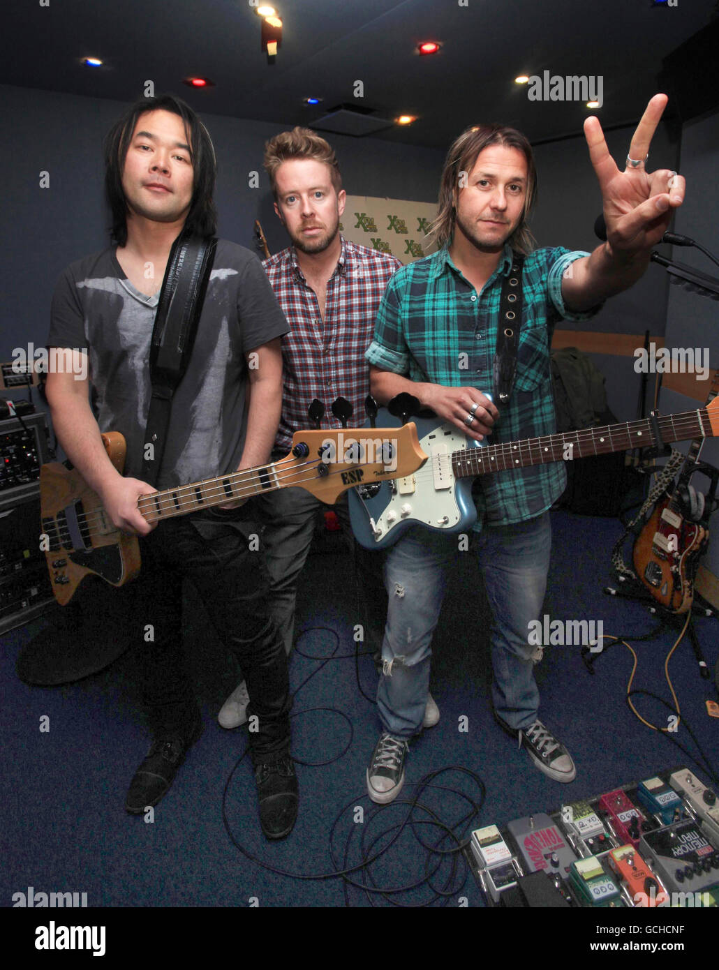 Alimentador (de izquierda a derecha) Taka Hirose, Karl Brasil y Grant Nicholas durante una sesión de estudio de XFM, en Leicester Square, en el centro de Londres. Foto de stock