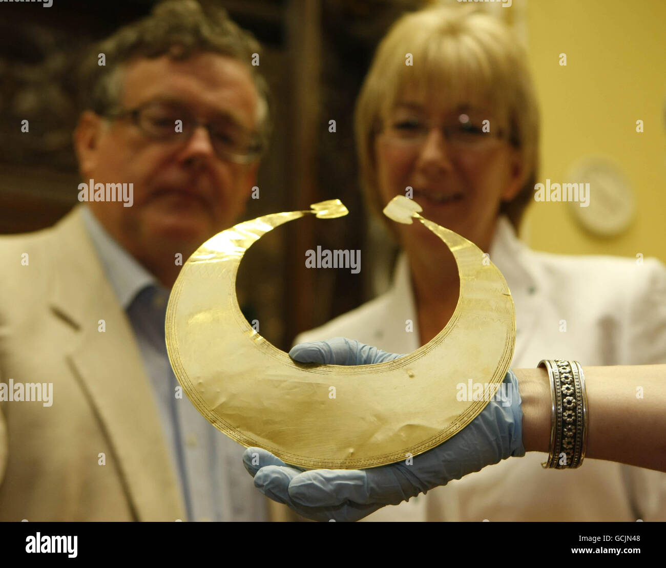 El Director Dr. Patrick Wallace y la Ministra de Artes Mary Hanafin miran la lunula de oro y dos discos de oro, que son artefactos de la Edad de Bronce Temprana, que fueron robados de una caja fuerte en Sheehan's Chemists, Strokestown, Co Roscommon en 2009 en el Museo Nacional de Irlanda, en Dublín. Foto de stock