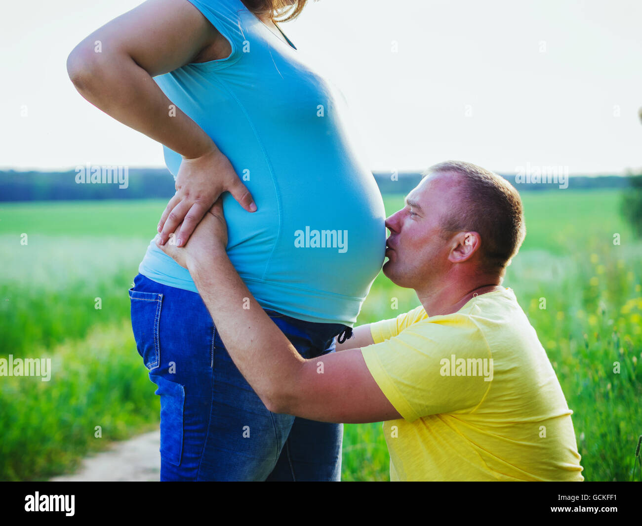 Hombre bese embarazada vientre de su esposa en el exterior Foto de stock