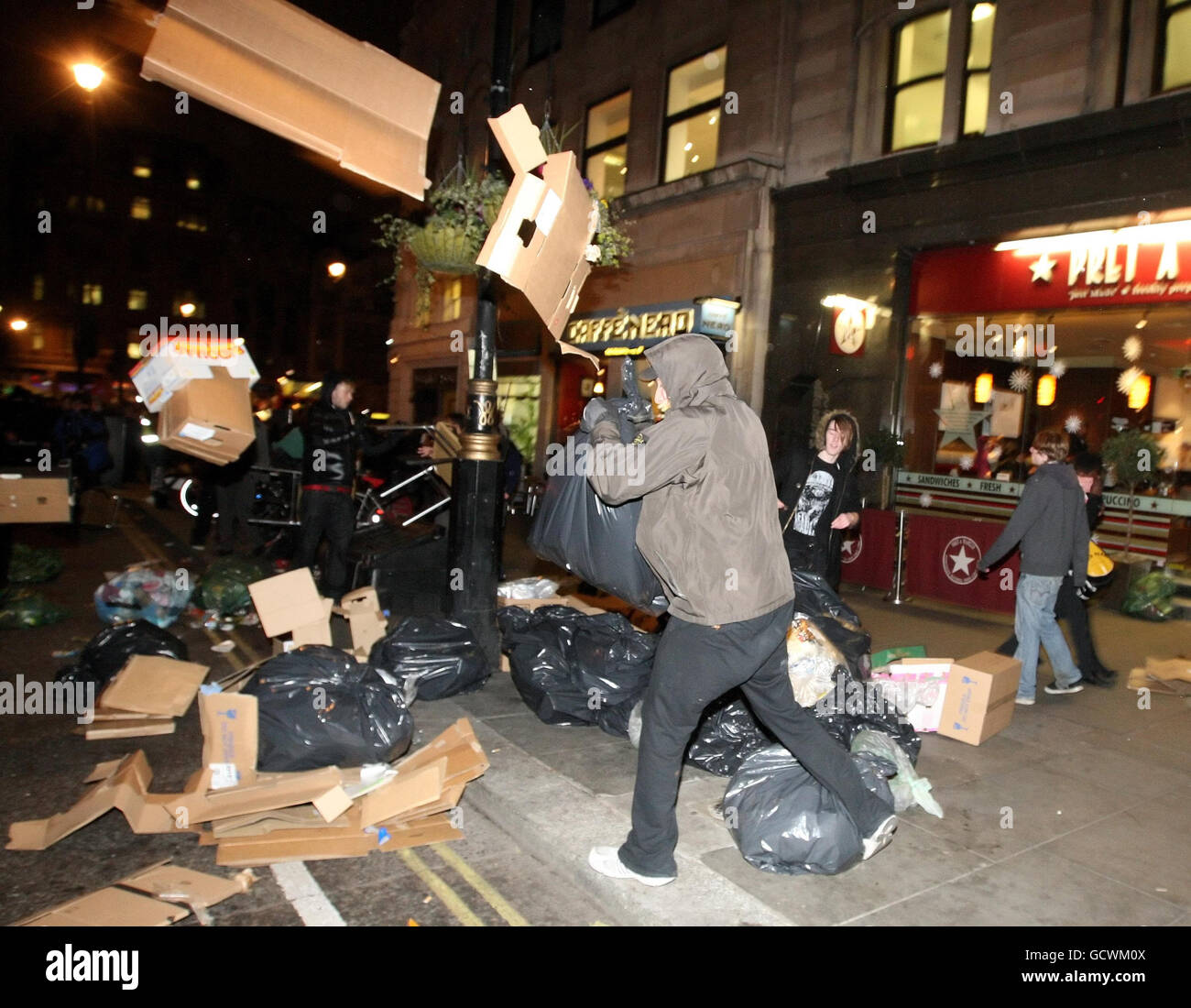 La gente tira basura cerca de Trafalgar Square, en el centro de Londres, después de las protestas en Westminster contra un aumento en los costos de matrícula universitaria. Foto de stock