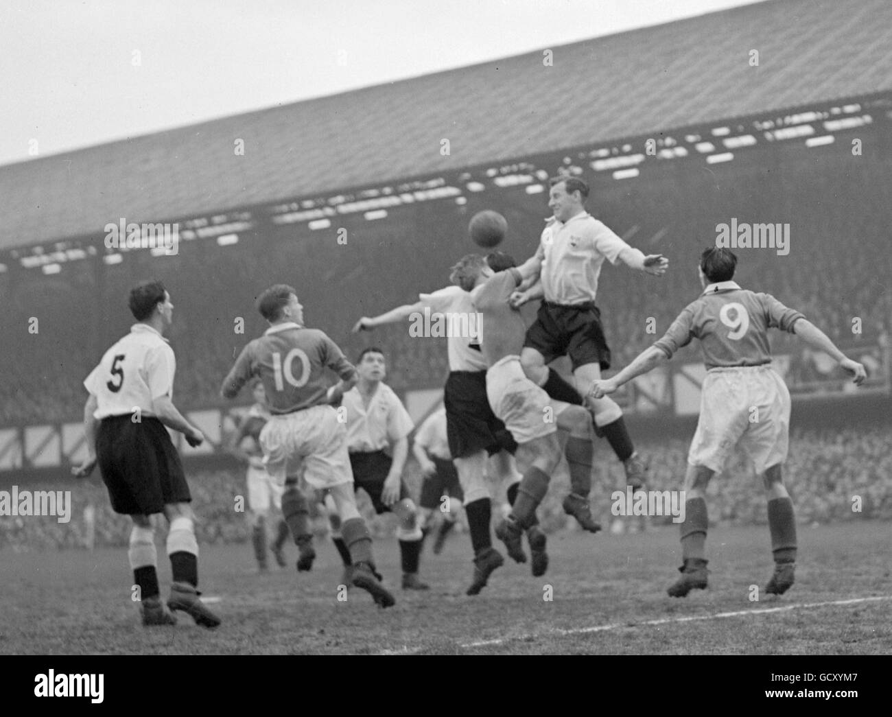 Jack Froggett de Portsmouth lucha con dos jugadores de Derby mientras que Derby Leon Leuty (No.5) y Ted Phillips de Portsmouth (N0,10) e Isaac Clarke (N0,9) Mira Foto de stock