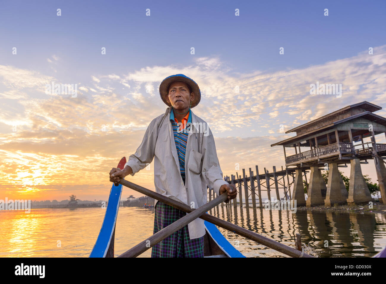 MANDALAY, MYANMAR - Octubre 28, 2015: un gondolero las palas sobre el lago Taungthaman en U-Bein Puente. Foto de stock