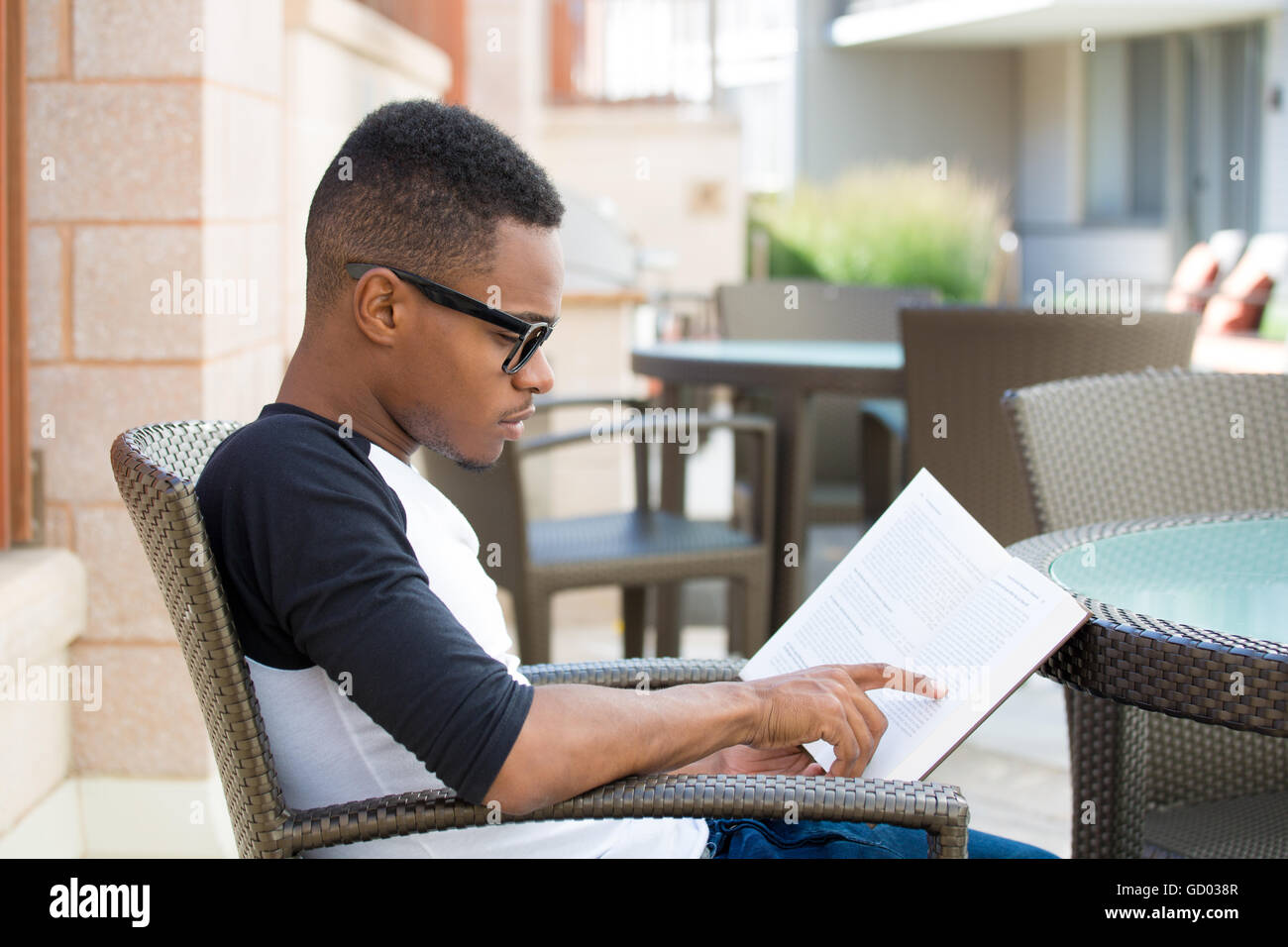 Closeup retrato inteligente, joven hombre nerdy con grandes gafas negras,  sentarse y leer, aislado en el exterior knowledg antecedentes Fotografía de  stock - Alamy