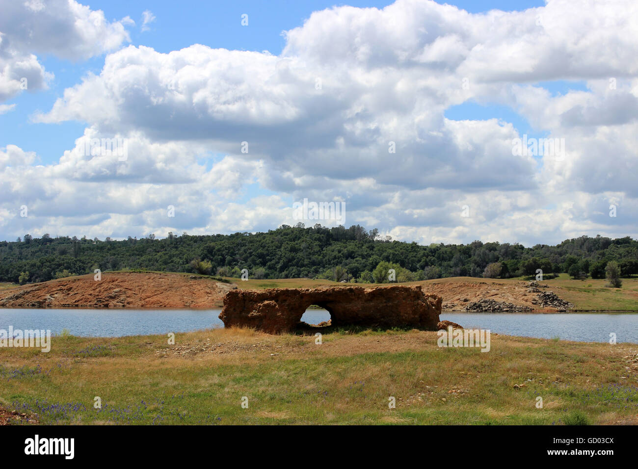 Puente natural de roca con el cielo azul y mullidas nubes Foto de stock