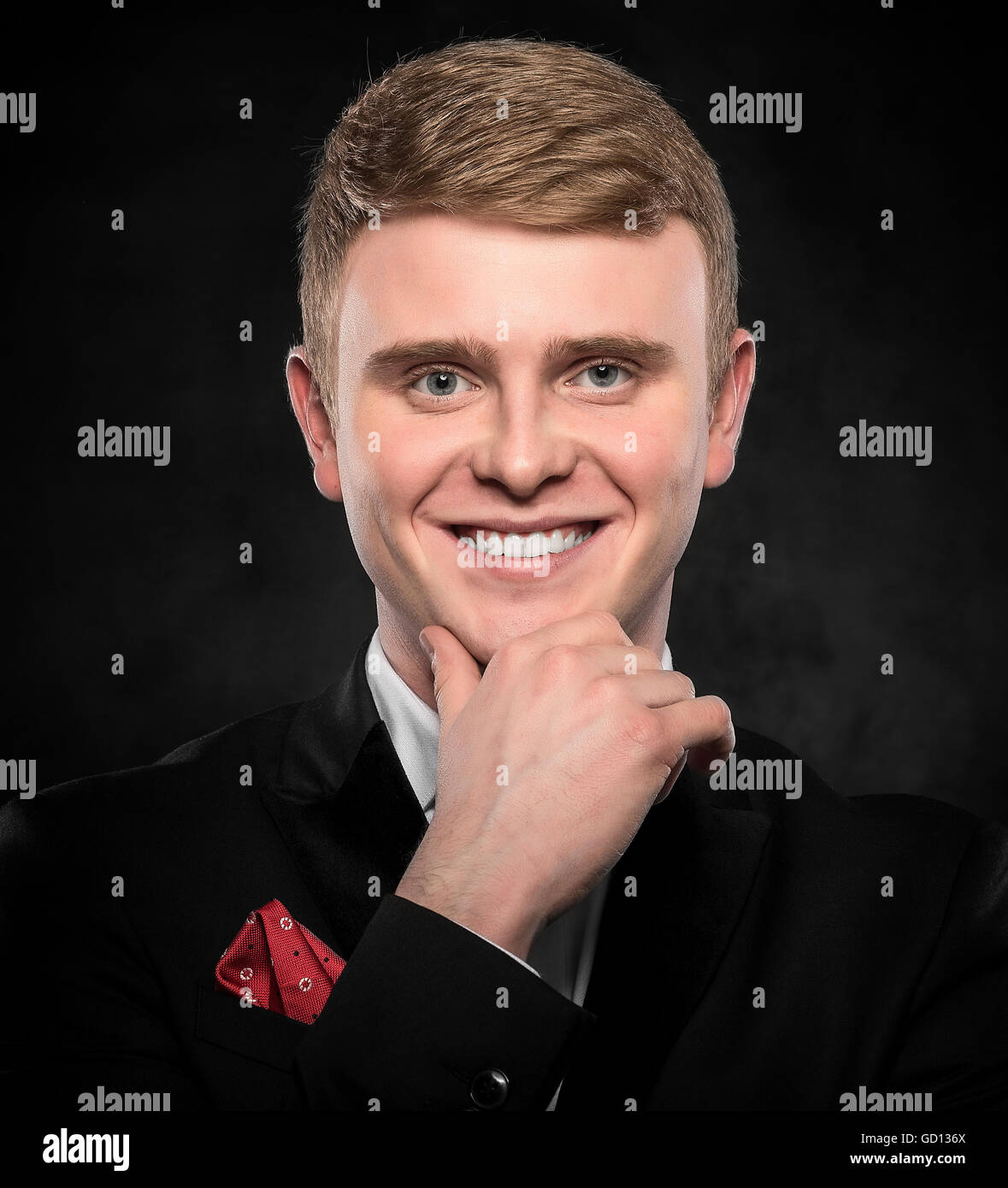 Joven guapo en traje sobre fondo oscuro. Foto de stock