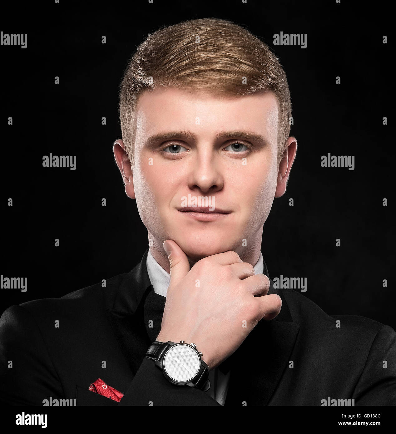 Joven guapo en traje sobre fondo oscuro. Foto de stock