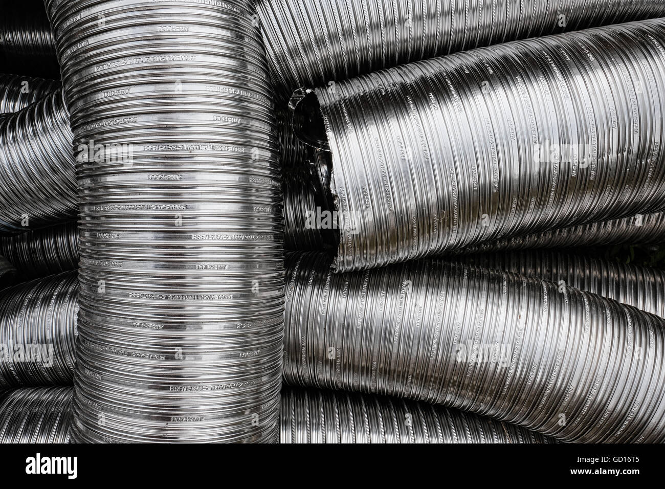 Tubos de metal flexible desechados utilizados para instalaciones de aire  acondicionado, vistos desechados en el patio de un constructor Fotografía  de stock - Alamy