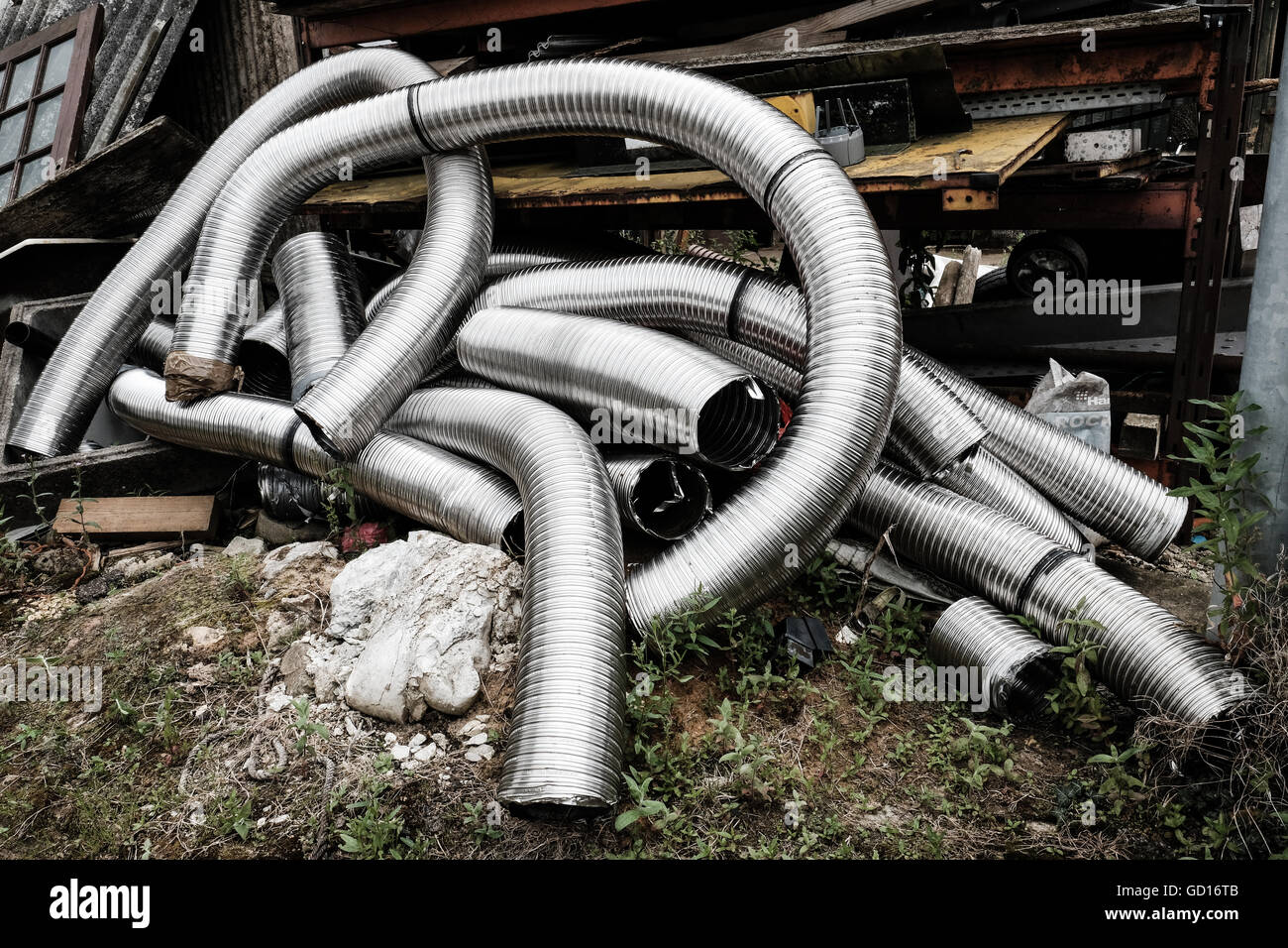 Tubos de metal flexible desechados utilizados para instalaciones de aire  acondicionado, vistos desechados en el patio de un constructor Fotografía  de stock - Alamy